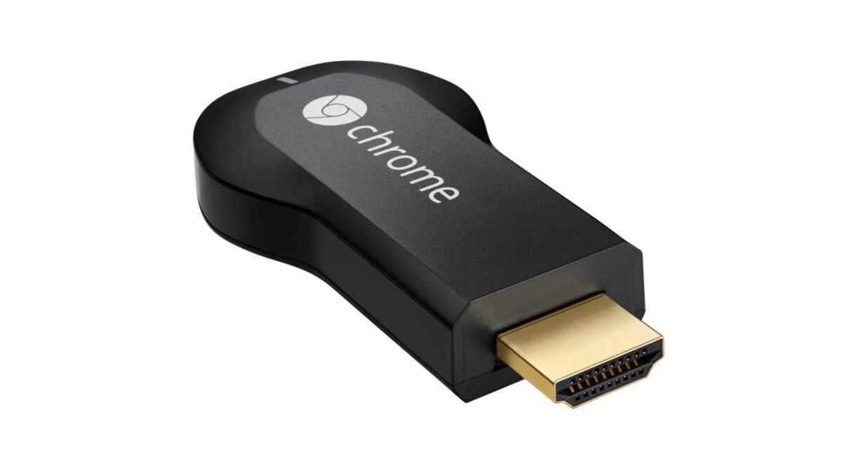 The 2013 first-generation Chromecast HDMI dongle next to its USB power cable