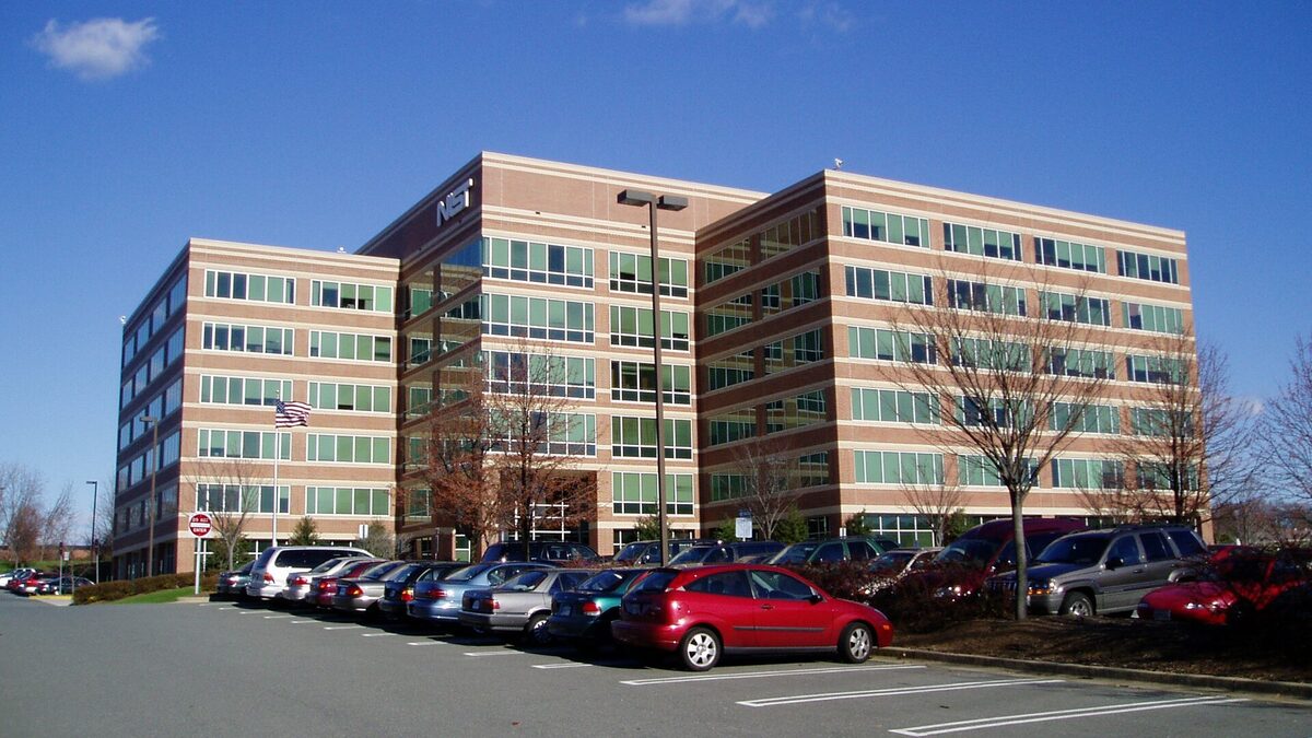 The NIST North Building in Gaithersburg, Maryland, a six-storey brick and glass office block with the NIST logo on its facade.